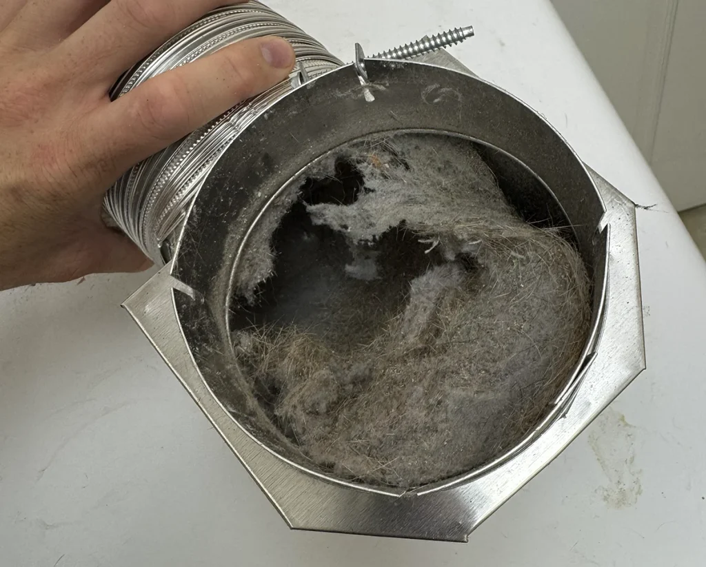 dryer vent duct filled with hair, lint, and contaminants.